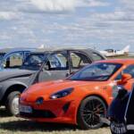 Voitures anciennes et plus récentes sous un ciel de plus en plus lumineux